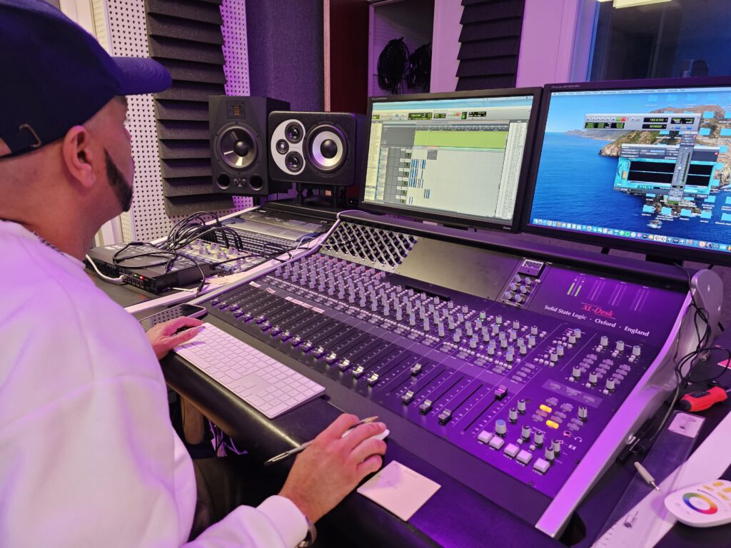 Membres de Roots Calling en pleine session d'enregistrement avec Marco Miolany dans le studio de Cooking Music, capturant l'énergie créative et la complicité.